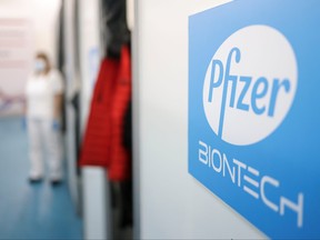 A health-care worker waits in front of a booth where people receive doses of Pfizer's COVID-19 vaccine at Belgrade Fair vaccination centre in Belgrade, Serbia, Oct. 15, 2021.