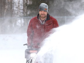 Chad Corson clears snow off the rink at the Oja Sports Complex in Naughton, Ont.