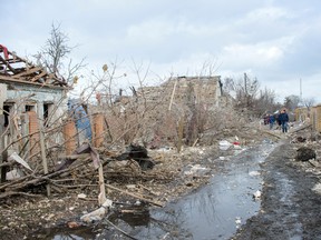 People walk near debris and houses destroyed by shelling, amid Russia's invasion of Ukraine, in Sumy, Ukraine, March 8, 2022 in this picture obtained from social media.