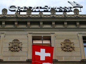 Switzerland's national flag flies below a logo of Swiss bank Credit Suisse at its headquarters at the Paradeplatz square in Zurich, July 31, 2019.