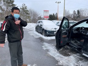 Sean Liu, co-owner of Sean's Auto Sales, prepares a car for display at his used car lot in Ottawa, March 12, 2022.