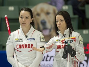 A cardboard cutout of a canine eavesdrops on a conversation between Team Canada skip Kerri Einarson (right) and third Val Sweeting during Canada's 9-3 victory over the U.S. at the world women's curling championship in Prince George, B.C., on March 24, 2022.