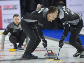 Team Wild Card 1 skip Brad Gushue watches as lead Geoff Walker (left) and second Brett Gallant (right) sweep during their team's win over team Wild Card 3 at the Tim Hortons Brier in Lethbridge on March 10, 2022.