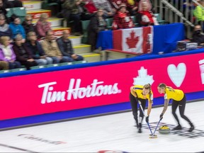 Sweden second Agnes Knochenhauer (left) and lead Sofia Mabergs sweep in front of a stone against Canada at the world women's curling championship in Prince George, B.C., on March 23, 2022.