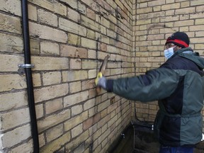 Anti-Semitic, homophobic and lewd graffiti was spray-painted on the rear walls on the Metropolitan United Church on Queen St. E. at Church St. over the weekend. A church worker uses a power washer, solvents and a wire brush to remove a swastika on Tuesday, March 8, 2022.