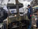 Freiwillige stellen am 9. März 2022 in Kiew in einem Lager am Straßenrand in der Nähe der nordöstlichen Frontlinie Lebensmittel her, um Soldaten und Zivilisten zu ernähren.