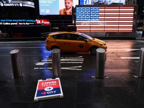 A sign advertising testing for COVID-19 is seen laid on the sidewalk in Times Square in Manhattan, New York City, March 12, 2022.