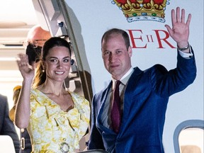 Catherine the Duchess of Cambridge and Britain's Prince William wave as they board a plane at Lynden Pindling International Airport in Nassau, The Bahamas on March 26, 2022.