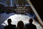 Participants check their messages on electronic devices during the World Economic Forum (WEF) annual meeting in Davos on Jan. 23, 2020.