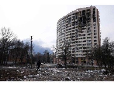 A man walks in front of a residential building damaged in yesterday's shelling in the city of Chernihiv on March 4, 2022.