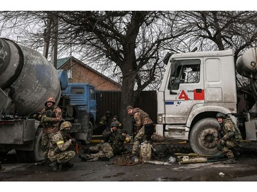 Ukrainian service men take cover from shelling in the city of Bucha, west of Kyiev, on March 4, 2022.