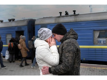 A couple embrace as they stand in front of an evacuation train at the central train station in Odesa on March 6, 2022.