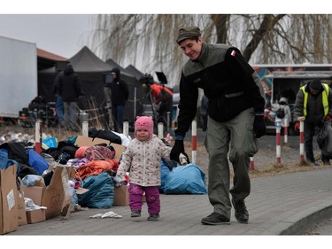 A Polish volunteer plays with a child in freezing cold temperatures, at the Medyka border crossing in Poland, on March 7, 2022.