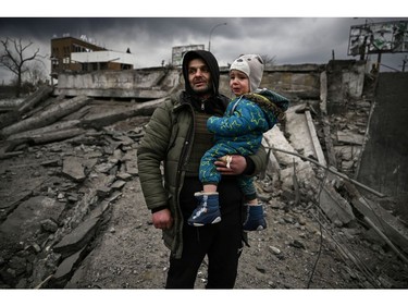 A man holds a child as he flees the city of Irpin, west of Kyiv, on March 7, 2022.