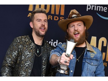 US musical duo Brothers Osborne members  T.J. (L) and John Osborne pose with the award for Duo of the Year in the press room during the 57th Academy of Country Music awards at the Allegiant stadium in Las Vegas, Nevada on March 7, 2022. (Photo by Bridget BENNETT / AFP)