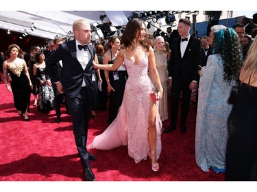 Lily James and guest walk on the red carpet during the Oscars arrivals at the 94th Academy Awards in Hollywood, Los Angeles, Calif., March 27, 2022.
