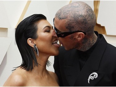 Kourtney Kardashian and Travis Barker kiss on the red carpet during the Oscars arrivals at the 94th Academy Awards in Hollywood, Los Angeles, Calif., March 27, 2022.