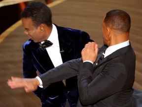 FILE PHOTO: Will Smith (R) hits Chris Rock as Rock spoke on stage during the 94th Academy Awards in Hollywood, Los Angeles, California, U.S., March 27, 2022.