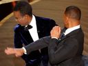 FILE PHOTO: Will Smith (R) hits Chris Rock as Rock spoke on stage during the 94th Academy Awards in Hollywood, Los Angeles, California, U.S., March 27, 2022. 