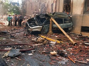 Police and rescue workers stand near destroyed cars and debris on March 17, 1992 in Buenos Aires shortly after a powerful bomb ripped through the Israeli Embassy, virtually destroying the five-story building and killing 29 people.