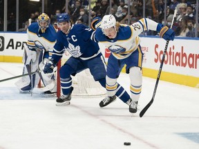Toronto Maple Leafs center John Tavares (91) battles for the puck with Buffalo Sabres defenseman Rasmus Dahlin (26) during the first period at Scotiabank Arena.