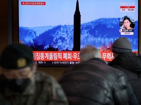 People watch a TV broadcasting file footage of a news report on North Korea firing what appeared to be a ballistic missile, in Seoul, South Korea, February 27, 2022.