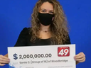 Sonia Correia-Batista holds the cheque for the Ontario 49 jackpot she and 15 other nurses won.