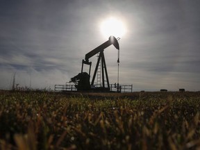 A pumpjack works at a well head on an oil and gas installation near Cremona, Alta., Saturday, Oct. 29, 2016.