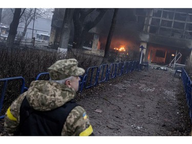 A member of the military walks near a building after a blast, amid Russia's invasion of Ukraine, in Kyiv, Ukraine March 1, 2022.