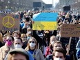 People hold signs at the anti-war concert "Sound for Peace", amid Russia's invasion of Ukraine, at the Brandenburg Gate in Berlin, Germany, March 20, 2022.