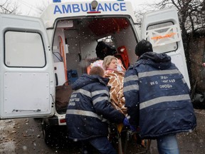 Medical specialists transport an injured woman to an ambulance following recent shelling in the separatist-controlled city of Donetsk, Ukraine, on March 3, 2022.