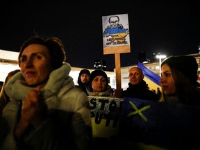 Protestors hold signs at a demonstration in support of Ukraine following Russia's invasion, as Ukrainian President Volodymyr Zelenskiy's speech is broadcasted to the Knesset, Israel's parliament, and projected at Habima square in Tel Aviv, Israel, March 20, 2022.