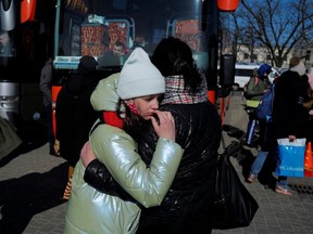 Angelica Honcharenko, 49, aus Kiew, umarmt ihre Tochter Albina, 11, nachdem sie vor der russischen Invasion in der Ukraine geflohen ist, bevor sie am 20. März 2022 vor dem Bahnhof in Lemberg, Ukraine, in einen Bus nach Düsseldorf in Deutschland einsteigen.