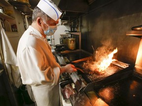 Peter Roubos, owner of The Times Square, broils a burger for a customer at his  Wlison Heights Blvd. restaurant on March 1, 2022.