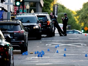 Evidence markers are seen on the ground at the crime scene after an early-morning shooting in a stretch of downtown near the Golden 1 Center arena in Sacramento, Calif., April 3, 2022.