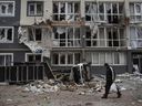 Ein Mann geht am 4. April 2022 in Bucha, Ukraine, an einem stark beschädigten Wohnhaus vorbei. 