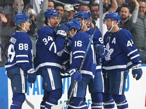 Auston Matthews of the Toronto Maple Leafs celebrates his 60th goal of the season with teammates during an NHL game against the Detroit Red Wings at Scotiabank Arena on April 26, 2022 in Toronto, Ontario, Canada.
