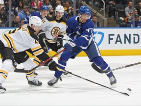Bruins’ Mike Reilly (left) battles against Maple Leafs’ Pierre Engvall at Scotiabank Arena last night.