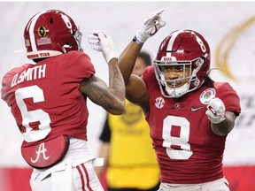 Wide receiver DeVonta Smith #6 of the Alabama Crimson Tide celebrates his touchdown with teammate wide receiver John Metchie III #8 interception he first quarter of the 2021 College Football Playoff Semifinal Game at the Rose Bowl Game presented by Capital One against Notre Dame Fighting Irish at AT&T Stadium on January 01, 2021 in Arlington, Texas.