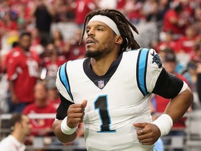 Quarterback Cam Newton #1 of the Carolina Panthers runs out to the field before the NFL game against the Arizona Cardinals at State Farm Stadium on November 14, 2021 in Glendale, Arizona.