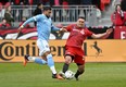 Toronto FC defender Shane O'Neill battles for the ball with New York City FC forward Valentin Castellanos.