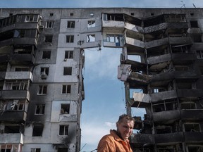 A clean-up worker walks past buildings that were destroyed by shelling, amid Russia's invasion of Ukraine in Borodyanka, in the Kyiv region, Ukraine, April 7, 2022.