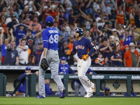 Toronto Blue Jays closer Jordan Romano walks off the field as Astros' Jeremy Pena rounds third after hitting a walk-off home run during the 10th inning at Minute Maid Park on Sunday.