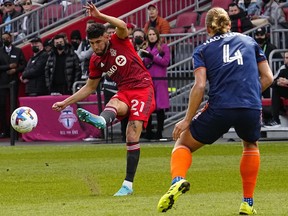 Toronto FC midfielder Jonathan Osorio (21) kicks the ball as FC Cincinnati defender Nick Hagglund (4) defends during the first half at BMO Field.