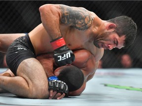 Raphael Assuncao (top) throws a punch against Rob Font during their bantamweight fight at T-Mobile Arena on July 7, 2018 in Las Vegas, Nevada.