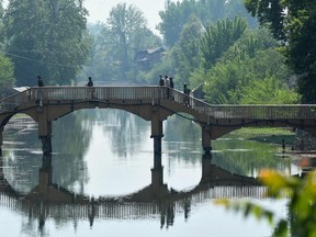 Indian paramilitary troopers patrol on a foot bridge near a site of a gunbattle between suspected militants and Indian government forces in Srinagar on April 10, 2022.