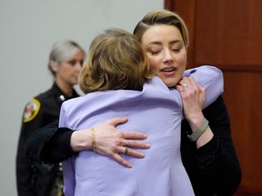 Actress Amber Heard hugs her attorney as she arrives in the courtroom at the Fairfax County Circuit Courthouse in Fairfax, Va., April 25, 2022.