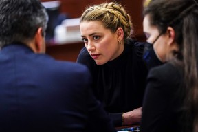 Actress Amber Heard sits with her legal team during the defamation trial at the Fairfax County Circuit Court in Fairfax, Va., on April 14, 2022.