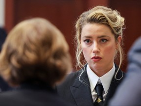 Actor Amber Heard speaks with her legal team as she attends Johnny Depp's defamation trial against her at the Fairfax County Circuit Courthouse in Fairfax, Virginia, April 13, 2022.