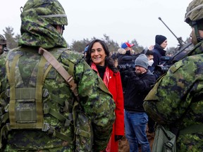 Canada's Minister of Defence Anita Anand talks with soldiers during a visit of the Adazi military base, north east of Riga, Latvia, on March 8, 2022.